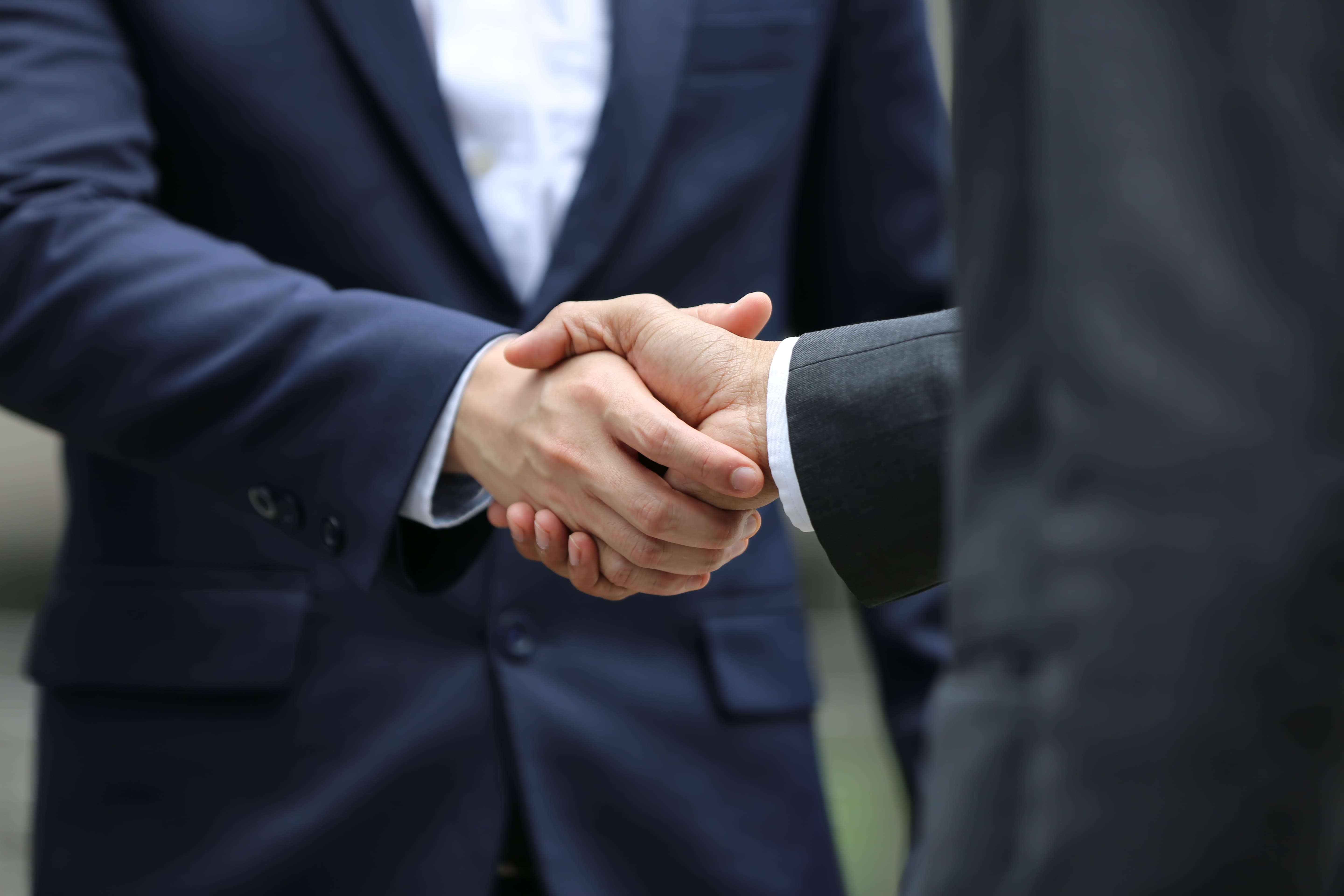 Business handshake representing Uoho sourcing partnership